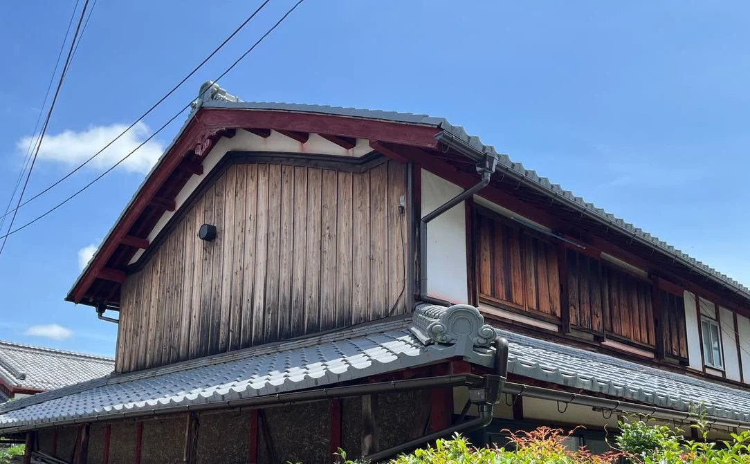 交換後の妻側。二段の屋根それぞれに新しい軒樋がまわり、鬼瓦まわりも整った状態
