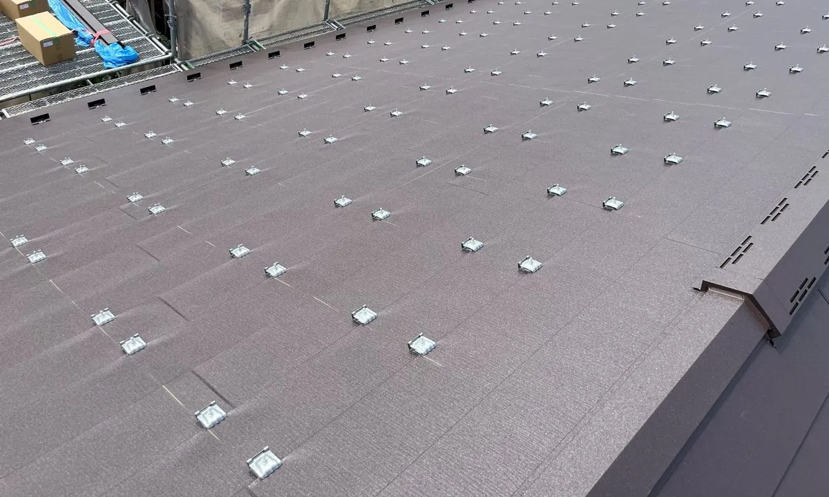 新しい金属屋根の上に、太陽光パネル用の取付金具を並べて取り付けた様子