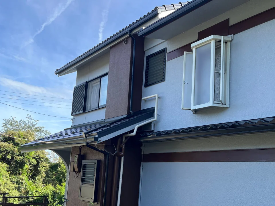 掛け替えた雨樋と塗り直した外壁が見える住宅の側面